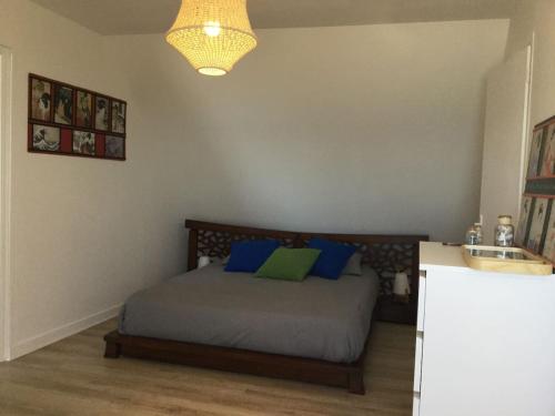 - une chambre avec un lit doté d'oreillers bleus et verts dans l'établissement LA MAISON DE LA PLAGE BEG LEGUER, à Lannion