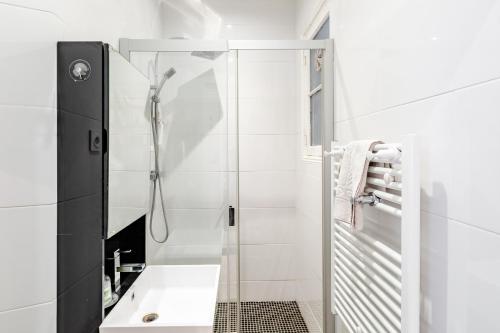 La salle de bains blanche est pourvue d'une douche et d'un lavabo. dans l'établissement LA JOLIETTE- Spacieux et lumineux, 4 couchages, à Marseille