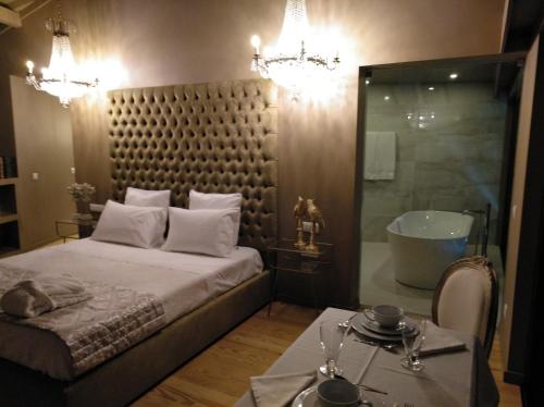 a bedroom with a large bed and a bath tub at Quinta do Burgo - Nature Hotel in Amares