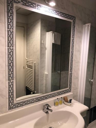 baño con lavabo y espejo grande en Venice Hotel, en Grisignano di Zocco