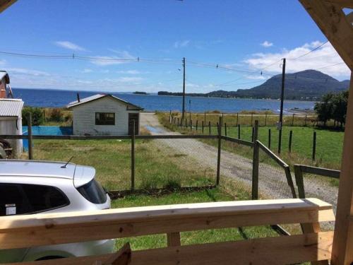 a car parked on a road next to a body of water at Cabaña frente al mar en Carretera Austral in Puerto Montt