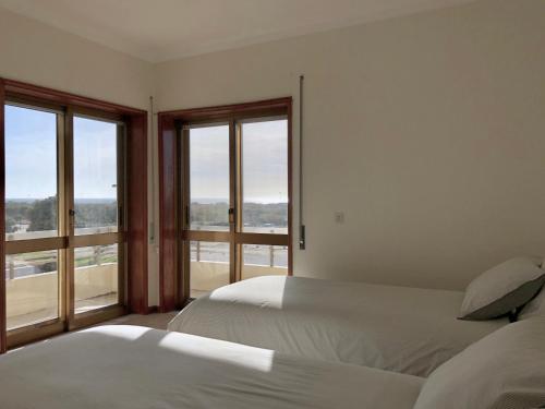 twee bedden in een kamer met twee ramen bij VMO Apartment in Vila do Conde