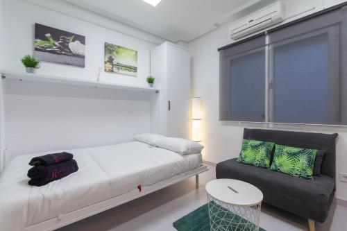una camera con letto, divano e finestra di Fuencarral Studio a Madrid