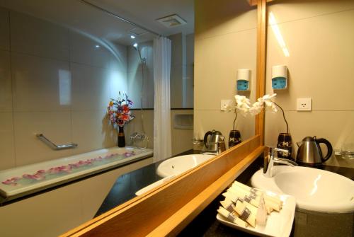 a bathroom with two sinks and a mirror and a tub at Hanoi Eternity Hotel in Hanoi