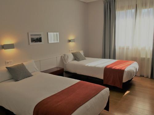 Habitación de hotel con 2 camas y ventana en Hotel Elorrio en Elorrio