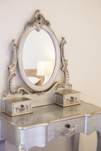 a mirror on top of a table with a lamp at Fair Oak House Exeter Airport in Exeter