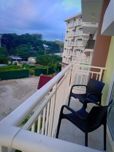 two chairs sitting on the balcony of a building at Amani Grand Resort Residences near Mactan Cebu Intl Airport in Mactan