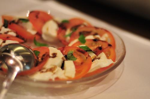 a plate of food with tomatoes and a spoon at Hotel Goldflair am Rathaus in Korbach