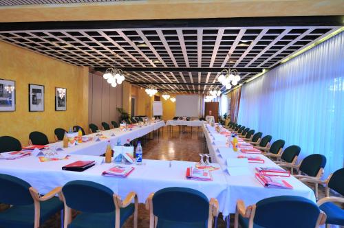 a group of tables in a room with blue chairs at Hotel Goldflair am Rathaus in Korbach