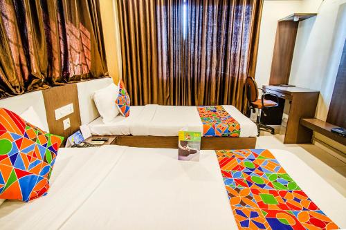 a hotel room with a bed and a desk at FabHotel Prime Sanket Inn, Phoenix Mall in Pune