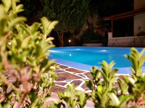 a blue swimming pool in a yard at night at Ancient Olympia Luxury Pool Villa Palace 4Bedroom in Olympia