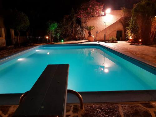 a swimming pool at night with a chair next to it at Ancient Olympia Luxury Pool Villa Palace 4Bedroom in Olympia