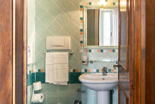 ein Bad mit einem Waschbecken und einem Spiegel in der Unterkunft Arco del vento in Assisi
