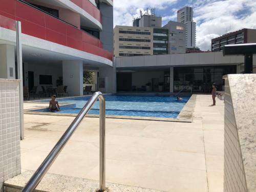 uma piscina ao lado de um edifício em Studio particular em Hotel em Salvador