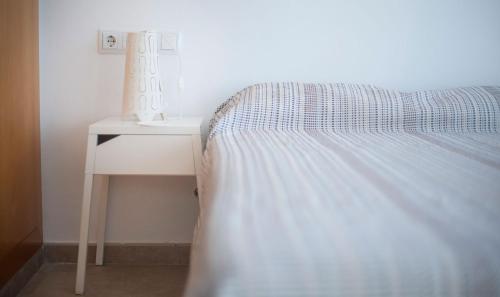 a bed with a night stand next to a side table at Eulalia Apartments, TarracoHomes in Altafulla