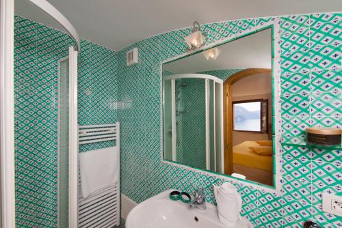 a bathroom with a mirror and a white sink at Residence Lì Galli in Praiano