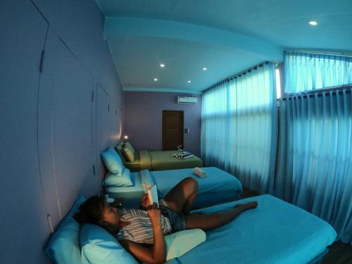 a man laying on a bed reading a book at Blue Coco in Keramas