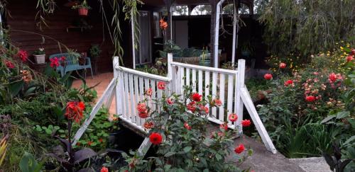una escalera de madera blanca en un jardín de flores en Au fruit delicieux, en Le Tampon