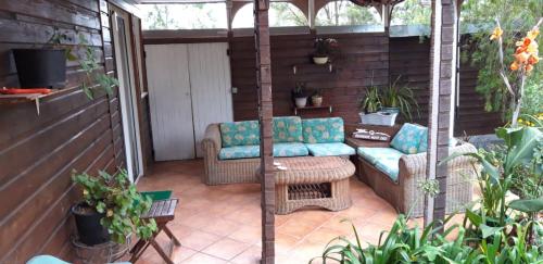 un patio con sofá y sillas en Au fruit delicieux, en Le Tampon
