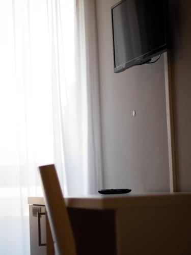 a room with a television on a wall with a chair at Master Hotel Reggio Emilia in Reggio Emilia