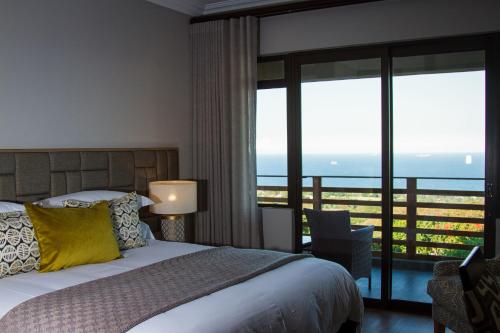 a bedroom with a bed and a view of the ocean at Endless Horizons Boutique Hotel in Durban