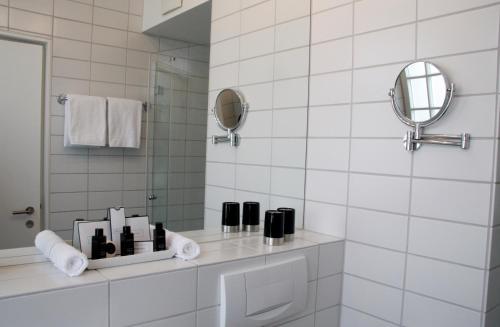 a white bathroom with a sink and a mirror at Gast - und Kulturhaus Der Teufelhof Basel in Basel