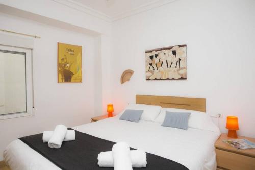 a white bedroom with a large white bed with pillows at Sivera-Centro Apartment in Valencia