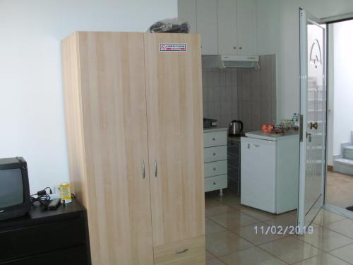 a wooden cabinet in the middle of a kitchen at Nina Rooms (apartments) in Artemida