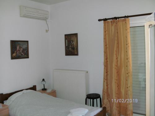 a bedroom with a bed and a window at Nina Rooms (apartments) in Artemida