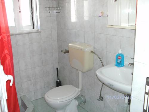 a bathroom with a toilet and a sink at Nina Rooms (apartments) in Artemida