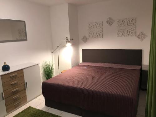 a bedroom with a bed and a dresser and a mirror at Ferienwohnung im Herzen der Holledau in Pörnbach