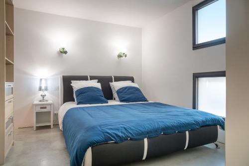 une chambre avec un lit avec des draps et des oreillers bleus dans l'établissement Maison piscine centre ville La Tranche-sur-Mer, à La Tranche-sur-Mer
