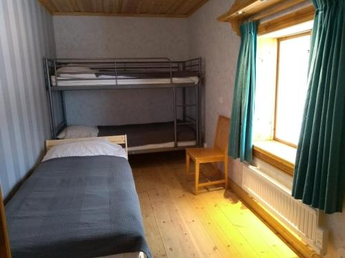 a bedroom with two bunk beds and a window at Kramer Stugan in Vikarbyn