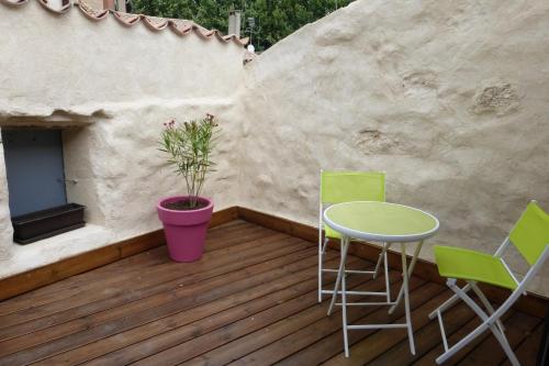 une terrasse avec une table, des chaises et une plante dans l'établissement La maison du Plo, à Fabrezan