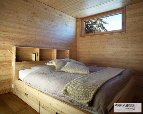 een slaapkamer met een bed in een houten hut bij Chalet "La Promesse" in Bagnes