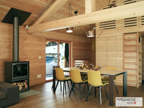 a dining room with a fireplace and a table and chairs at Chalet "La Promesse" in Bagnes