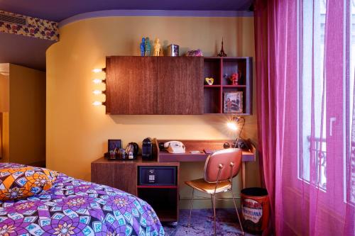 a bedroom with a desk and a bed with a pink bedspread at 25hours Hotel Terminus Nord in Paris