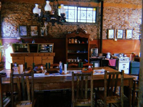 a dining room with a table with chairs and a kitchen at Posada Ribera del Gualeguaychu in Gualeguaychú