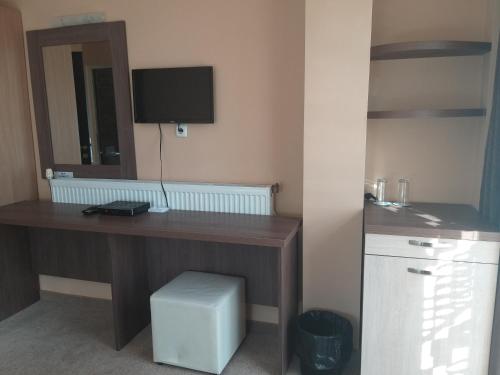 Zimmer mit einem Schreibtisch, einem Computer und einem TV. in der Unterkunft Family Hotel Relax in Streltscha