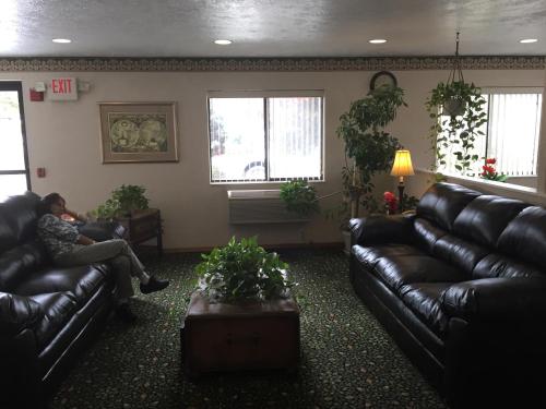 a person sitting on a couch in a living room at Super 8 by Wyndham New Stanton in New Stanton