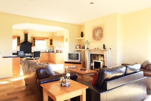 a living room with leather couches and a table at Barr Cill Atha in Kenmare