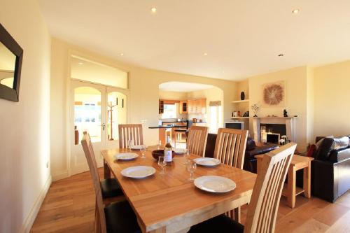 a dining room and kitchen with a wooden table and chairs at Barr Cill Atha in Kenmare