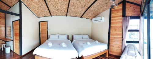 a bedroom with two beds in a room at Baan Krupong in Ban Tha Thong Mon