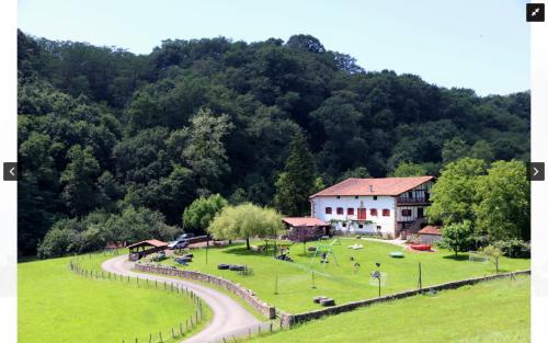 a building in the middle of a field next to a road at Casa Rural Iratxeko-Berea in Bera
