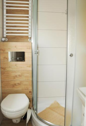 a bathroom with a toilet and a shower at Ośrodek Wczasowy GAMA in Rewal