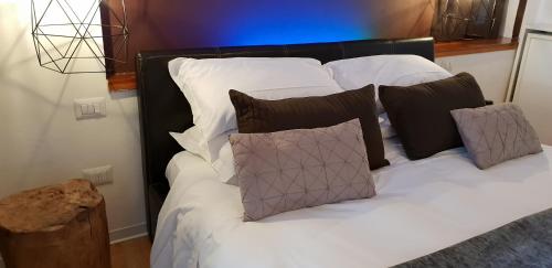 a bed with white sheets and brown pillows at Casa Lady in Garda