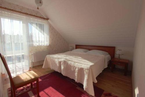 a bedroom with a bed and a large window at Ośrodek Wczasowy GAMA in Rewal