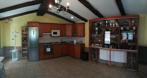 eine Küche mit Holzschränken und einem Kühlschrank in der Unterkunft Lezamakoetxe in Sopuerta
