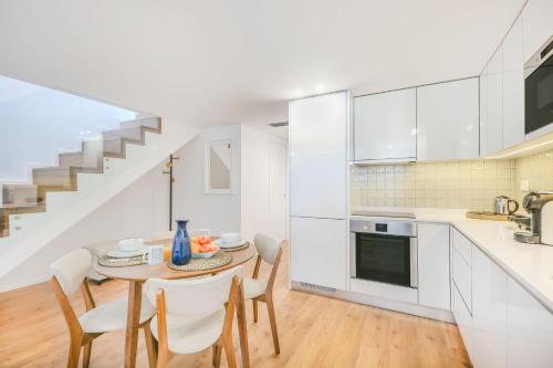 a kitchen with a table and chairs and a staircase at Porto City Elegant Retreat in Porto