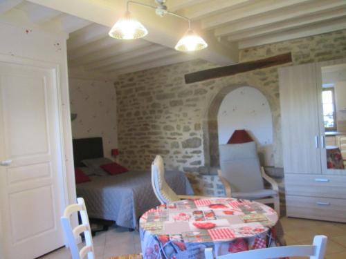 une chambre avec un lit, une table et des chaises dans l'établissement Le clos de la perdrix, à Bellenot-sous-Pouilly